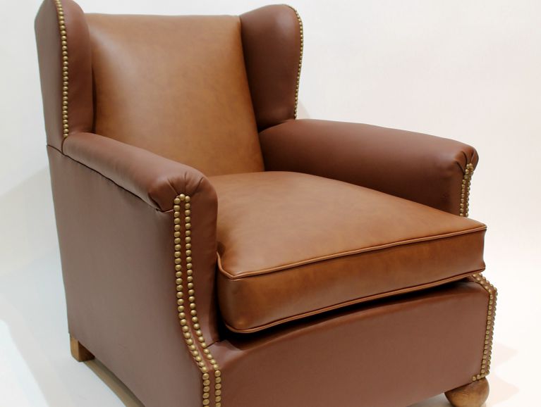 Complete refurbishment of a Club wing chair covered with a leather mix from the Tassin publisher and a vinyl from the Casal publisher, studded finish