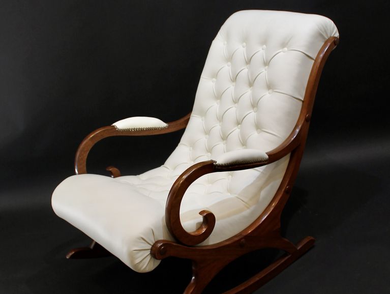 Réfection complète d'un fauteuil capitonné à bascule Chesterfield modèle Slippers recouvert d'un cuir de chez Tassin finition cloutée