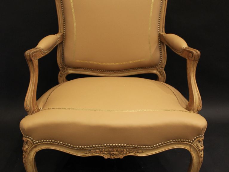 Réfection complète d'un fauteuil cabriolet de style Louis XV - Cuir Tassin avec application d'une vignette dorée à la feuille d'or , finition cloutée